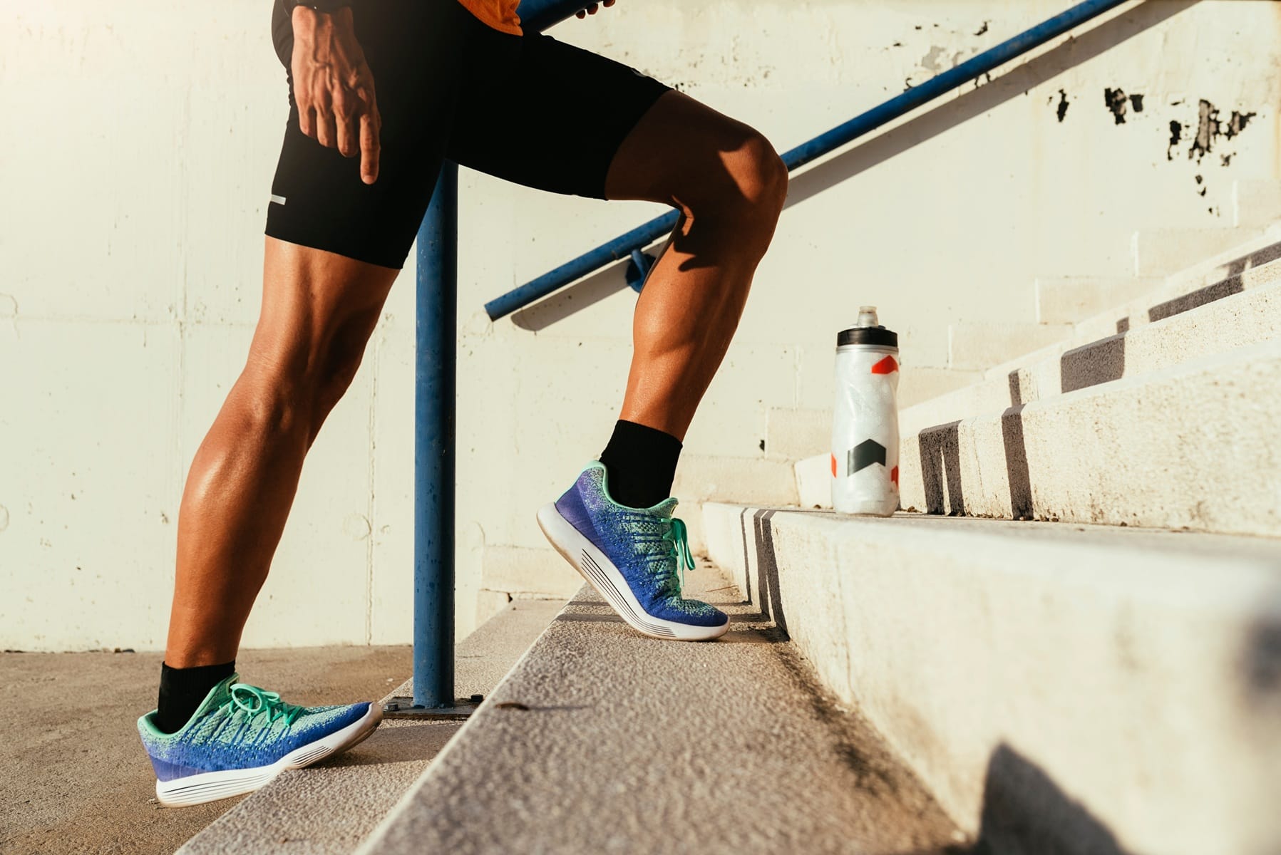 Biegacz rozciągający mięśnie łydek po ukończeniu maratonu
